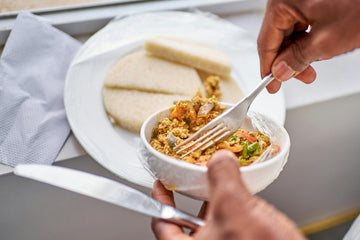 Image showing a person holding a plate of fried eggs and boiled yam